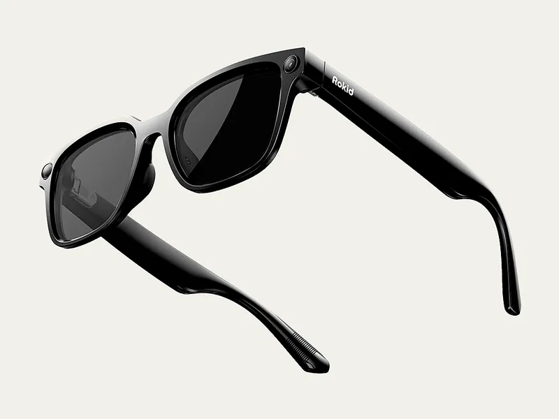 Rokid AI Glasses Style in glossy black with tinted lenses, showing the front camera and Rokid logo on the temple